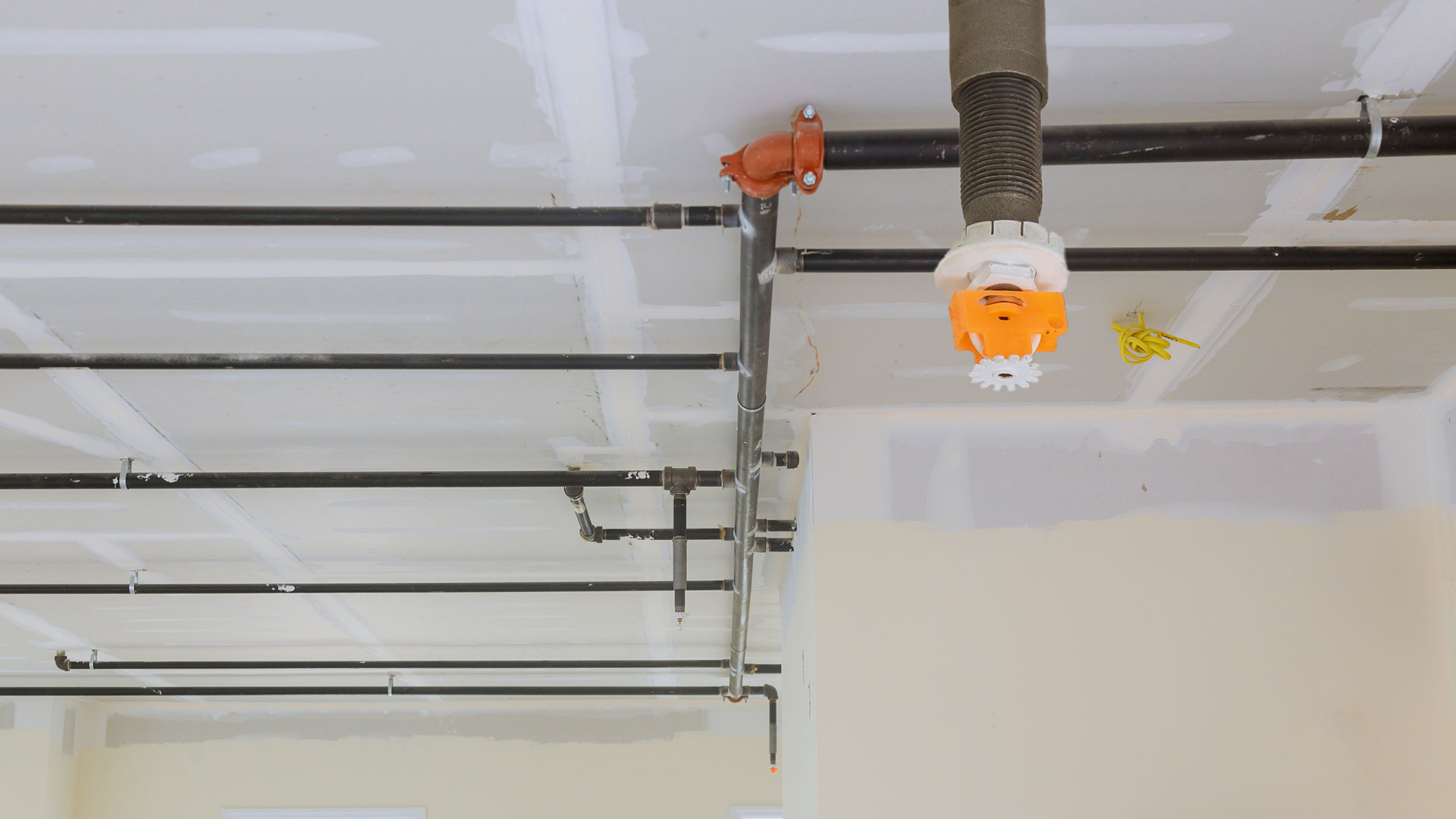 Sistema de sprinklers e tubagem instalado no teto de um edifício.