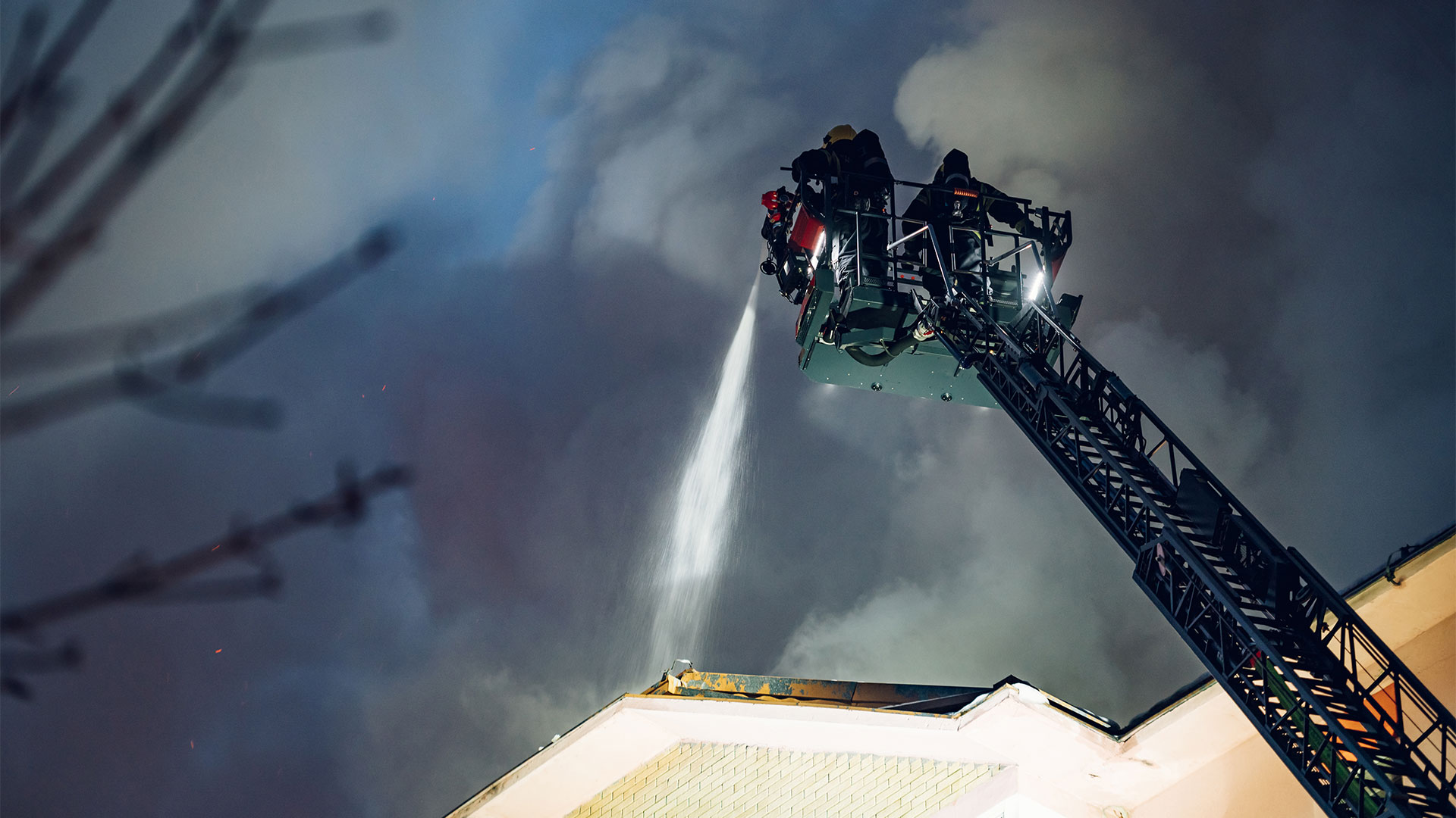 Bombeiro a projetar água durante o combate a um incêndio.